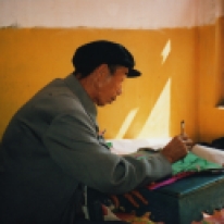 Li Manshan doing paperwork for Hoisting the Pennant ritual, 2003 https://stephenjones.blog/the-film/